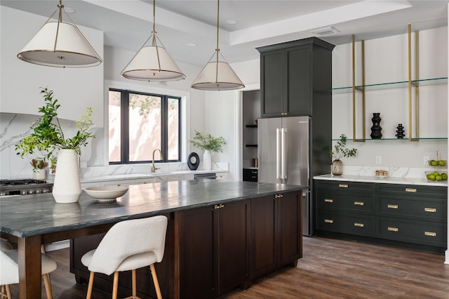 kitchen featuring pendant lighting, sink, high end refrigerator, backsplash, and dark hardwood / wood-style flooring