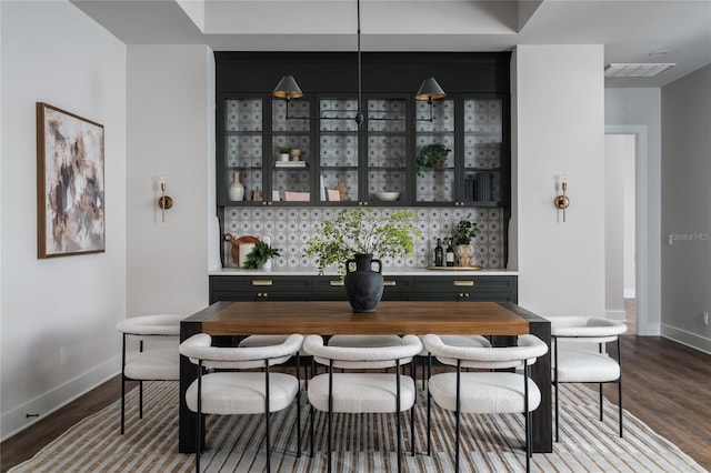 bar featuring hardwood / wood-style flooring and backsplash