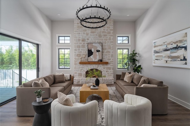 living room featuring plenty of natural light, a stone fireplace, and dark hardwood / wood-style flooring