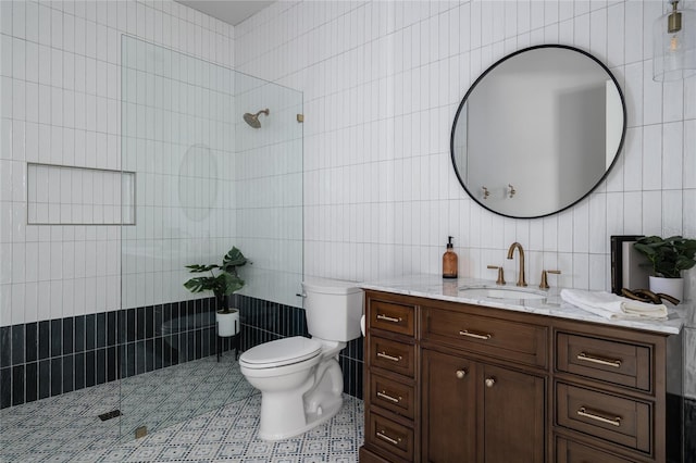 bathroom with a shower, tile walls, tile patterned flooring, vanity, and toilet