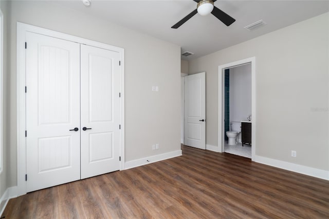 unfurnished bedroom with ceiling fan, connected bathroom, dark hardwood / wood-style flooring, and a closet