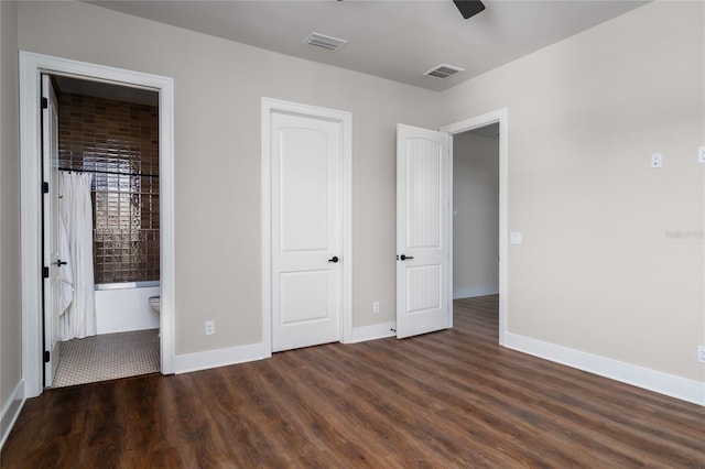 unfurnished bedroom with dark hardwood / wood-style flooring and ensuite bathroom