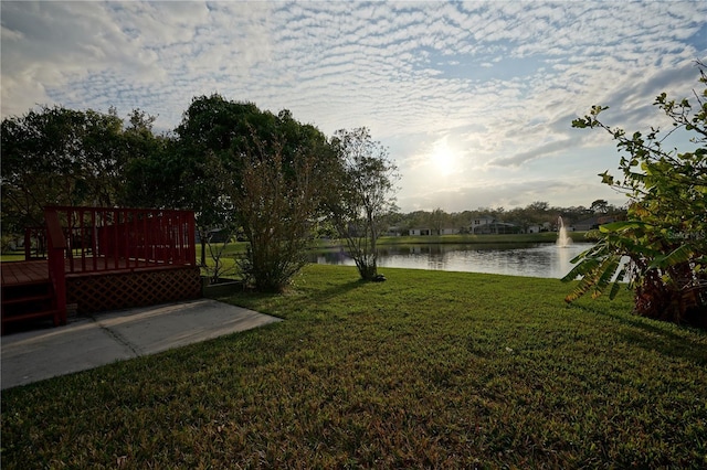 view of yard with a deck with water view