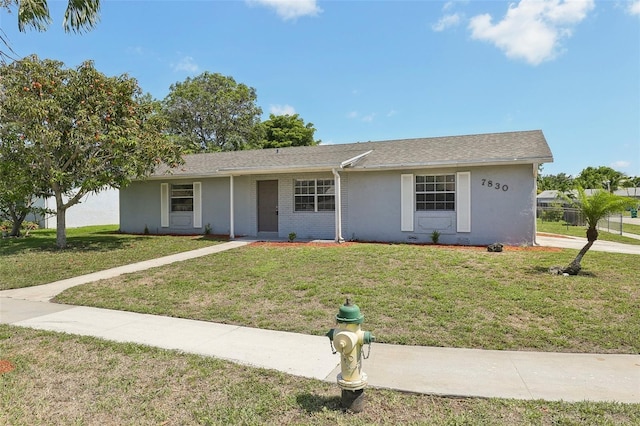 single story home featuring a front lawn