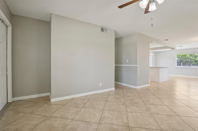 tiled spare room with ceiling fan