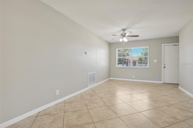 tiled spare room with a textured ceiling and ceiling fan