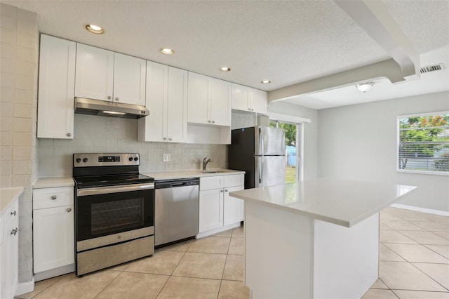 kitchen featuring white cabinetry, appliances with stainless steel finishes, light tile patterned floors, and backsplash