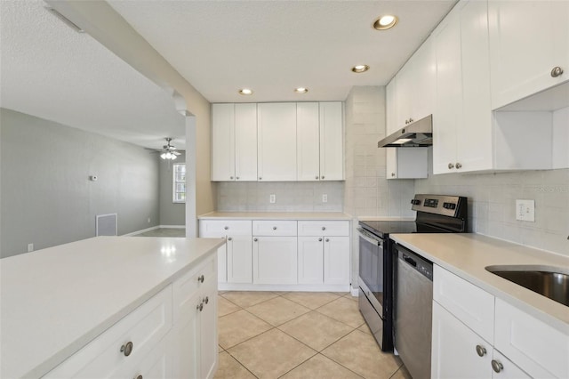 kitchen with tasteful backsplash, sink, white cabinets, light tile patterned floors, and stainless steel appliances