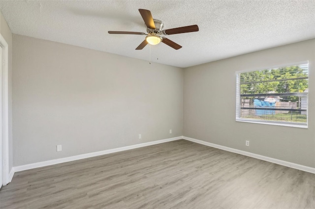 empty room with wood-type flooring, ceiling fan, and a textured ceiling