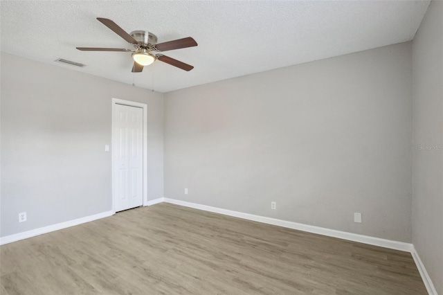 spare room with hardwood / wood-style floors, a textured ceiling, and ceiling fan