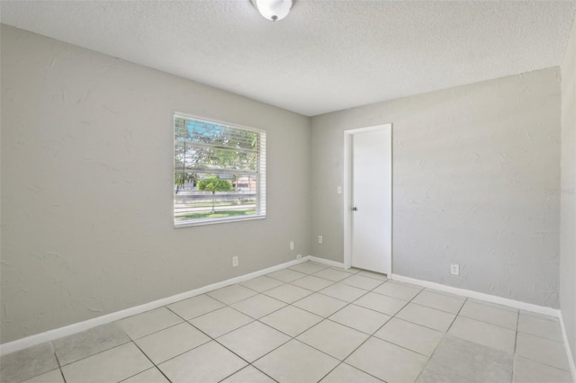 tiled spare room featuring a textured ceiling