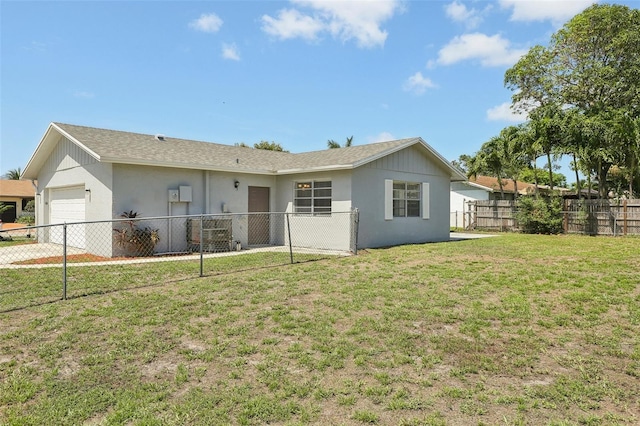 back of house with a garage and a lawn