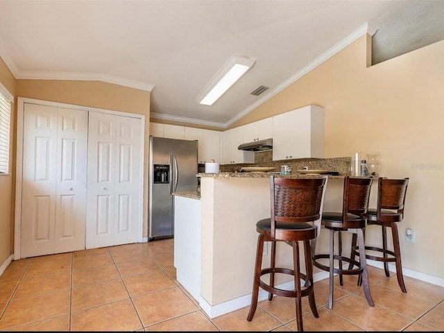 kitchen featuring white cabinets, crown molding, stainless steel fridge, and kitchen peninsula