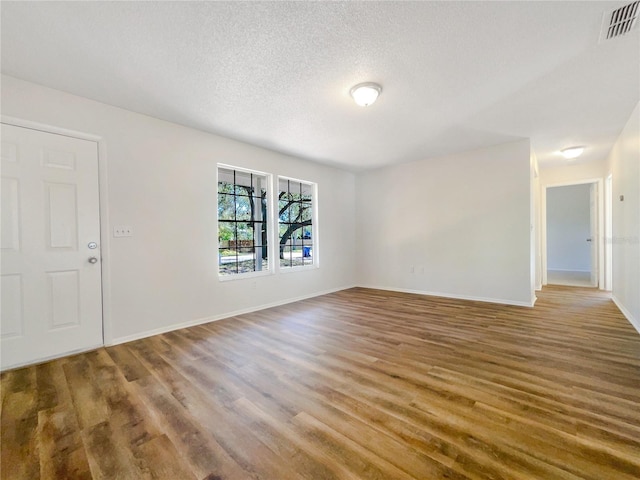 empty room featuring hardwood / wood-style floors and a textured ceiling