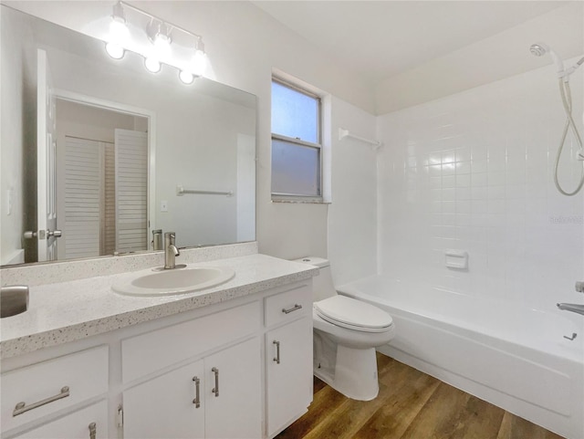 full bathroom with wood-type flooring, shower / washtub combination, vanity, and toilet