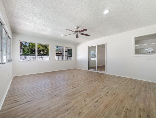 empty room featuring ceiling fan, a textured ceiling, and light wood-type flooring