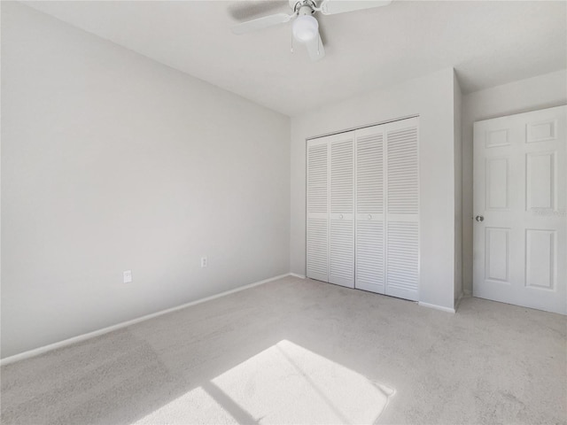 unfurnished bedroom featuring light colored carpet, a closet, and ceiling fan