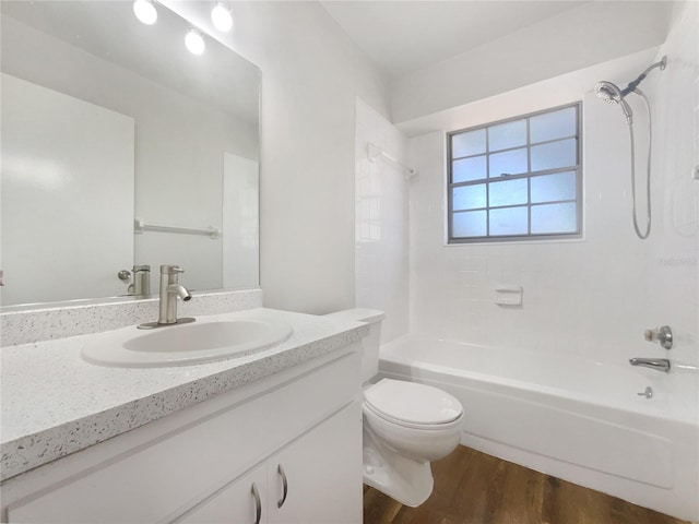 full bathroom featuring hardwood / wood-style flooring, tiled shower / bath, vanity, and toilet