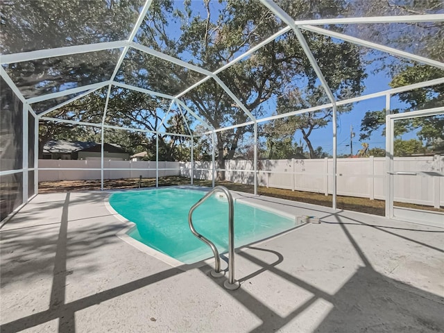 view of pool with a patio and glass enclosure