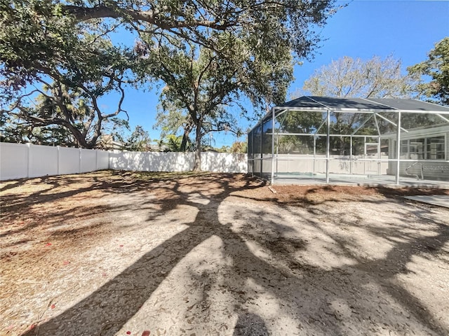 view of yard with a lanai and a swimming pool