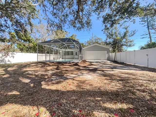 rear view of house with a garage and a lanai