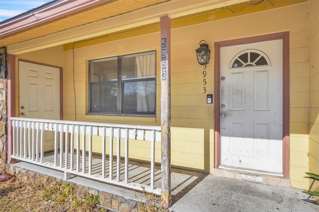 view of exterior entry featuring covered porch