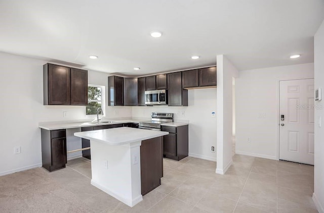 kitchen with dark brown cabinetry, stainless steel appliances, a center island, and sink