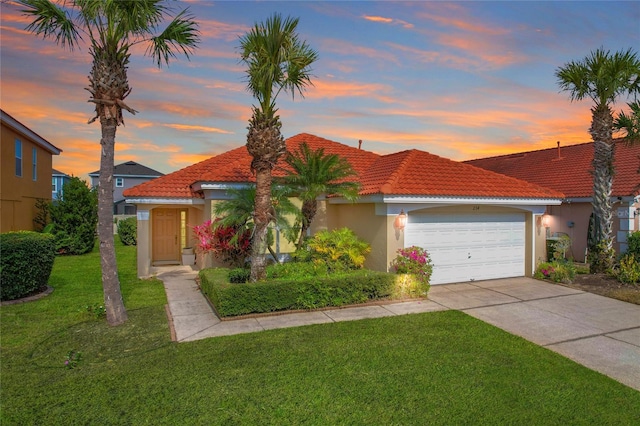 mediterranean / spanish-style home featuring a garage and a lawn