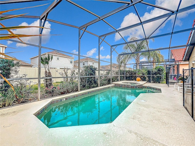 view of pool featuring an in ground hot tub, a patio area, and glass enclosure