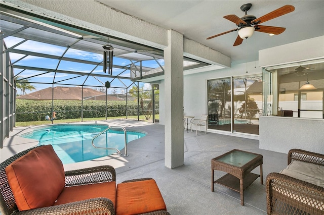 view of swimming pool with ceiling fan, a patio, a mountain view, and glass enclosure