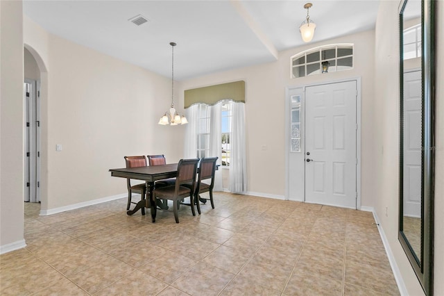 tiled dining area with a chandelier