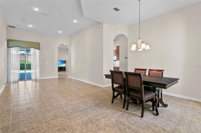 dining space with light tile patterned flooring and an inviting chandelier