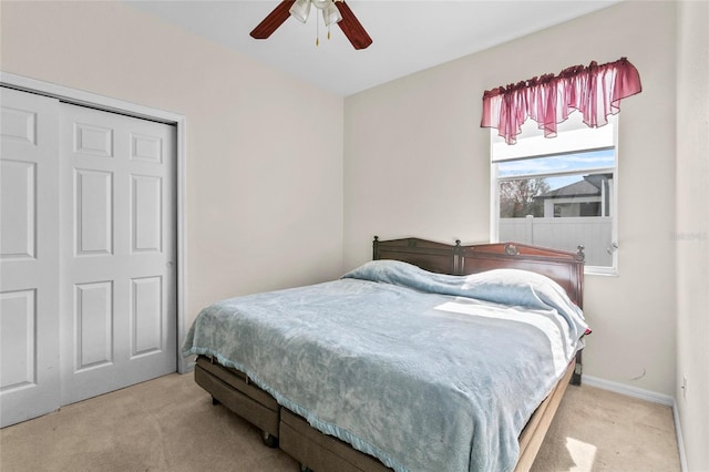 carpeted bedroom with ceiling fan and a closet