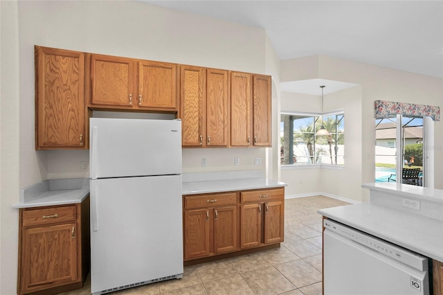 kitchen with hanging light fixtures, white appliances, vaulted ceiling, and light tile patterned flooring