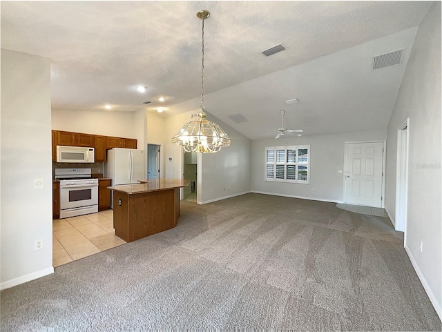 kitchen featuring white appliances, a center island, hanging light fixtures, and light carpet