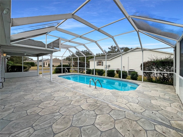 view of swimming pool featuring glass enclosure and a patio area