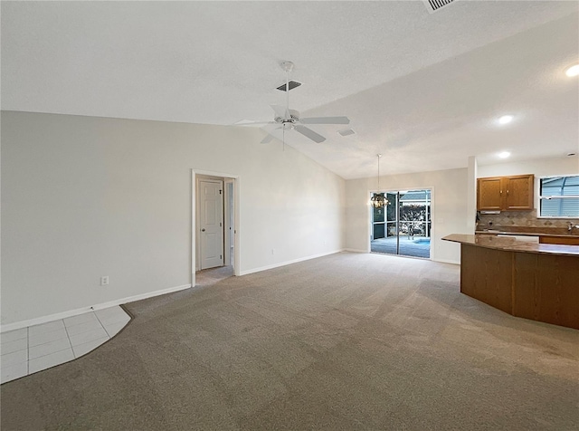 unfurnished living room with a textured ceiling, vaulted ceiling, light colored carpet, and ceiling fan