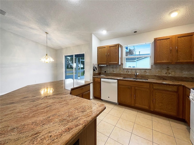 kitchen with pendant lighting, sink, lofted ceiling, white dishwasher, and decorative backsplash