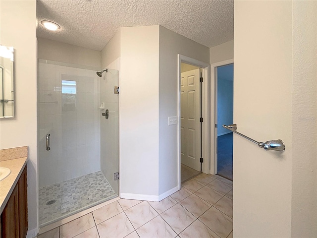 bathroom featuring tile patterned flooring, vanity, a textured ceiling, and walk in shower