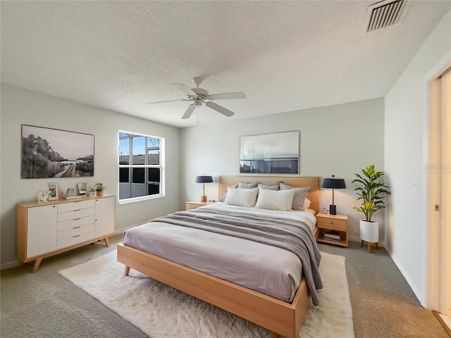 bedroom with light colored carpet, a textured ceiling, and ceiling fan