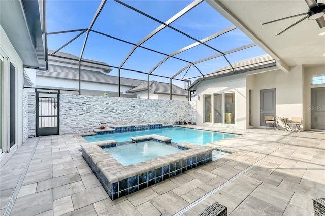 view of swimming pool with a lanai, a patio, ceiling fan, and an in ground hot tub