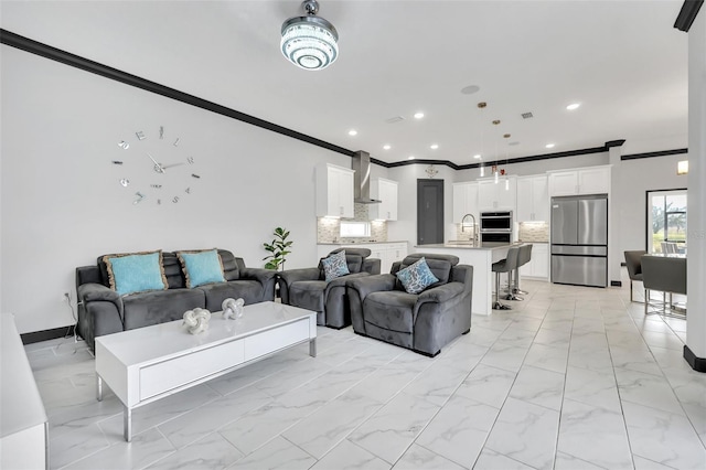 living room with ornamental molding and sink