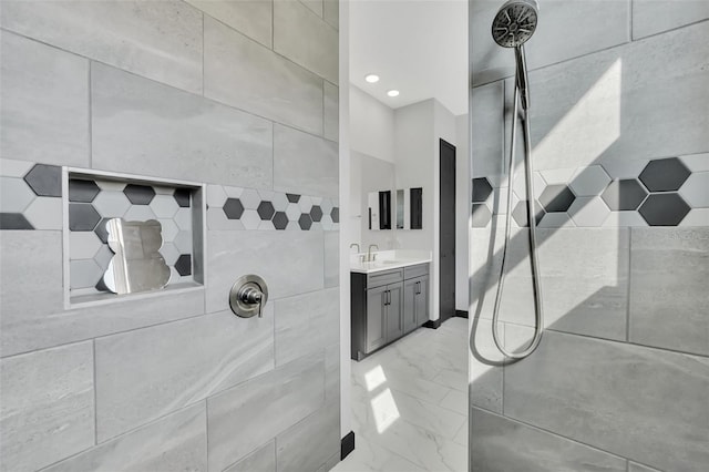 bathroom with vanity and a tile shower