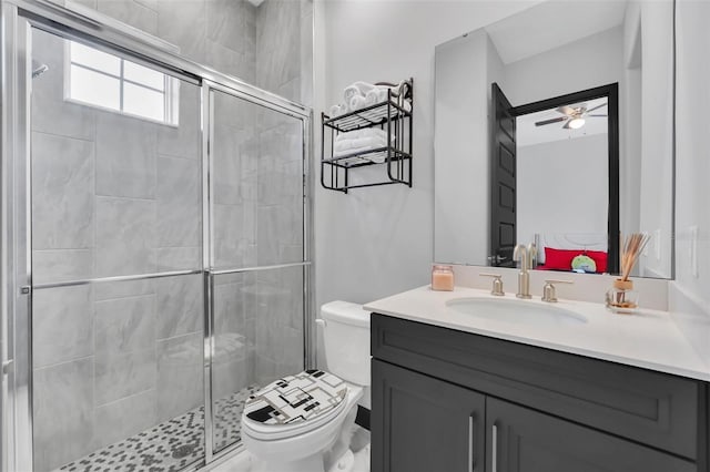 bathroom featuring vanity, ceiling fan, a shower with shower door, and toilet