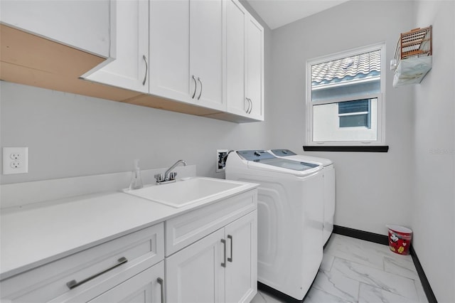 washroom featuring washer and dryer, sink, and cabinets