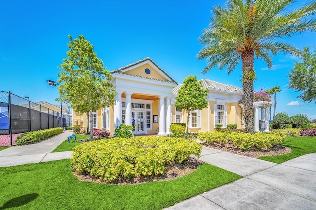 greek revival house with a front yard and french doors