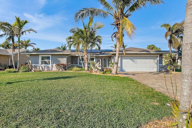 single story home featuring a garage, solar panels, and a front lawn