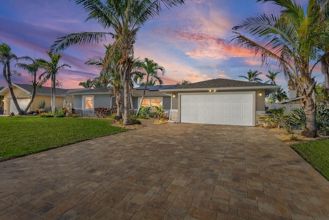 ranch-style home with a yard and a garage