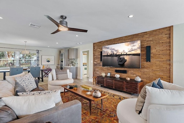 living room featuring ceiling fan and light hardwood / wood-style floors