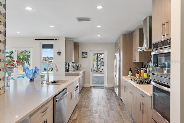 kitchen with sink, light brown cabinets, and appliances with stainless steel finishes